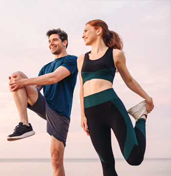 Mann und Frau beim Stretching im Freien; COOODEX® Serum für Muskeln und Gelenke zur Unterstützung der Regeneration nach dem Sport.